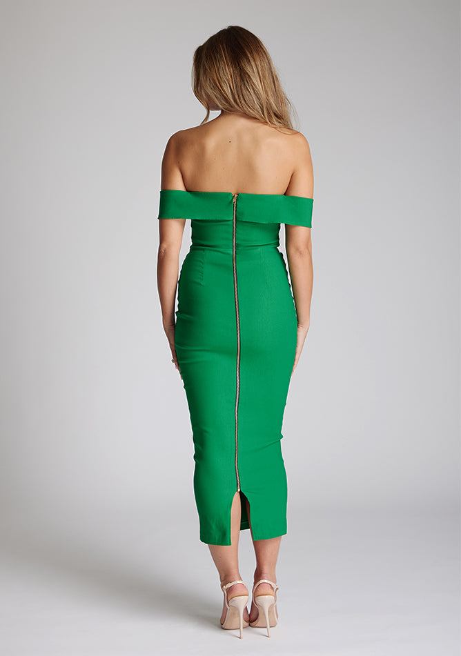 Back image of a model wearing a emerald green midaxi dress with a off-shoulder bardot neckline, with arm bands v-shaped cut-out at neckline and keyhole cut-out under bust and bodycon style dress with a statement gold zip at centre back. The design featured is the Vesper Daphne Emerald Green Midaxi Dress