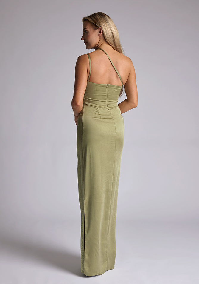 Back quarter image of a model wearing an olive satin maxi dress with a cross strap detail, pleats detailing at the front bust and delicate side skirt split. The design featured is the Vesper Solange Olive Satin Maxi Dress