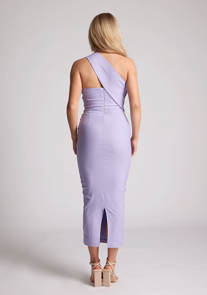 Back image of blonde model wearing lilac one shoulder midaxi dress with a unique one-sleeve design, asymmetric cut neckline, bycon fit, back zip and closure short split. The design featured is the Vesper Teo Lilac One Shoulder Midaxi Dress