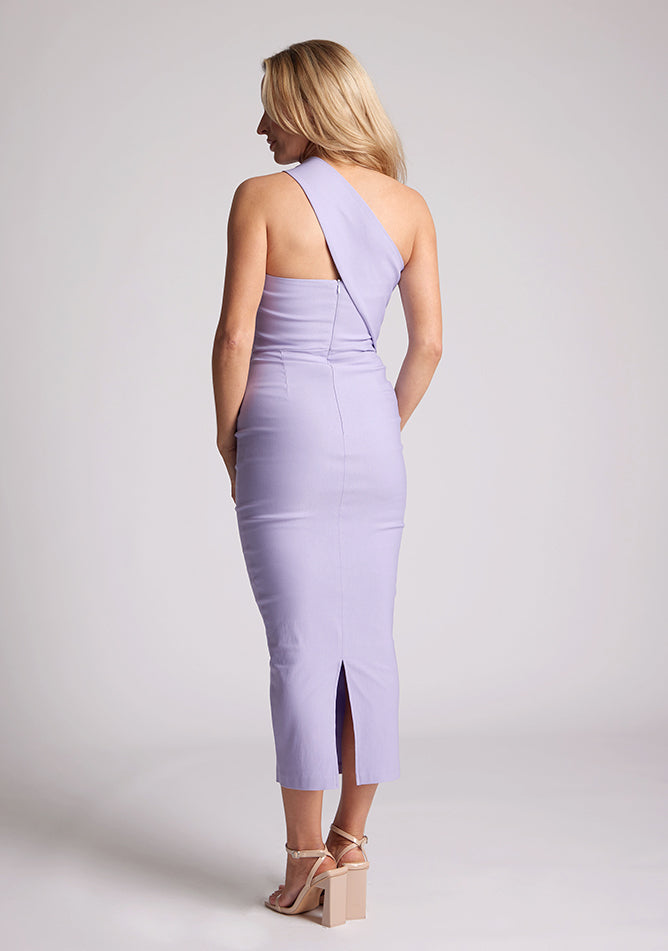 Back quarter image of blonde model wearing lilac one shoulder midaxi dress with a unique one-sleeve design, asymmetric cut neckline, bycon fit, back zip and closure short split. The design featured is the Vesper Teo Lilac One Shoulder Midaxi Dress