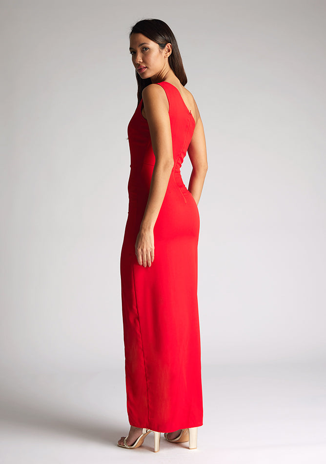 Back quarter image of model wearing red asymmetric maxi dress with a asymmetric neckline with one shoulder detail, front bodice cut-out and front skirt split. The design featured is Vesper Verity Red Asymmetric Maxi Dress