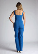 Back image of a model wearing a petrol blue jumpsuit, featuring a square neck, wide leg and sleeveless design. The design featured  is the Vesper Alana Petrol Blue Wide Leg Jumpsuit