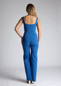 Back image of a model wearing a petrol blue jumpsuit, featuring a square neck, wide leg and sleeveless design. The design featured  is the Vesper Alana Petrol Blue Wide Leg Jumpsuit