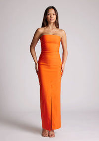 Front image of a model wearing a orange strapless maxi dress with a front split and centre back zip. The design featured is the Vesper Alaya strapless maxi dress