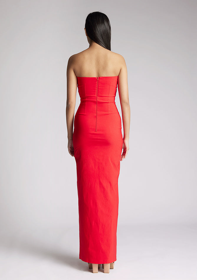 Back image of a model wearing a red strapless maxi dress with a front split and centre back zip. The design featured is the Vesper Alaya strapless maxi dress