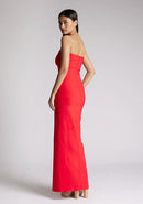  Back quarter image of a model wearing a red strapless maxi dress with a front split and centre back zip. The design featured is the Vesper Alaya strapless maxi dress