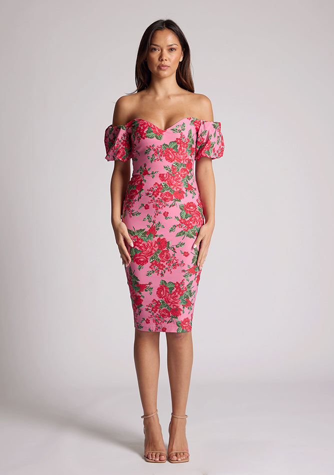 Front image of a model wearing a floral bardot dress, featuring puff sleeves and a midi length. The dress featured is the Anastasia Pink Floral Bardot Midi Dress