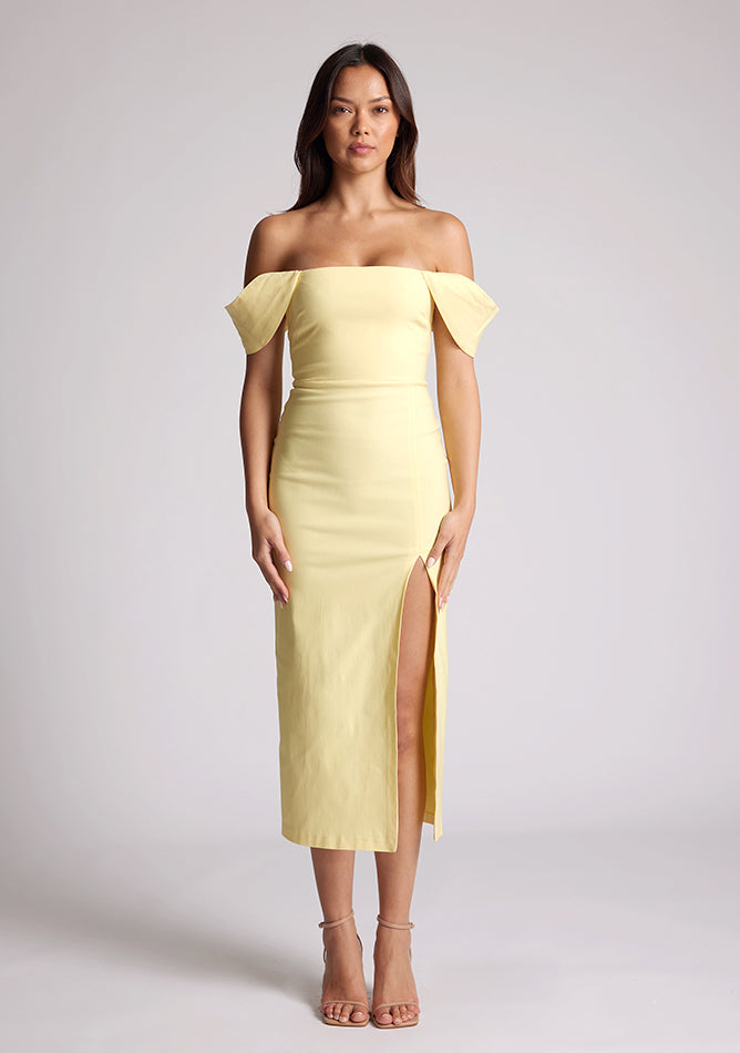 Front image of a model wearing a yellow bardot dress, with a front split. The dress featured is the Astra sherbert bardot midaxi dress