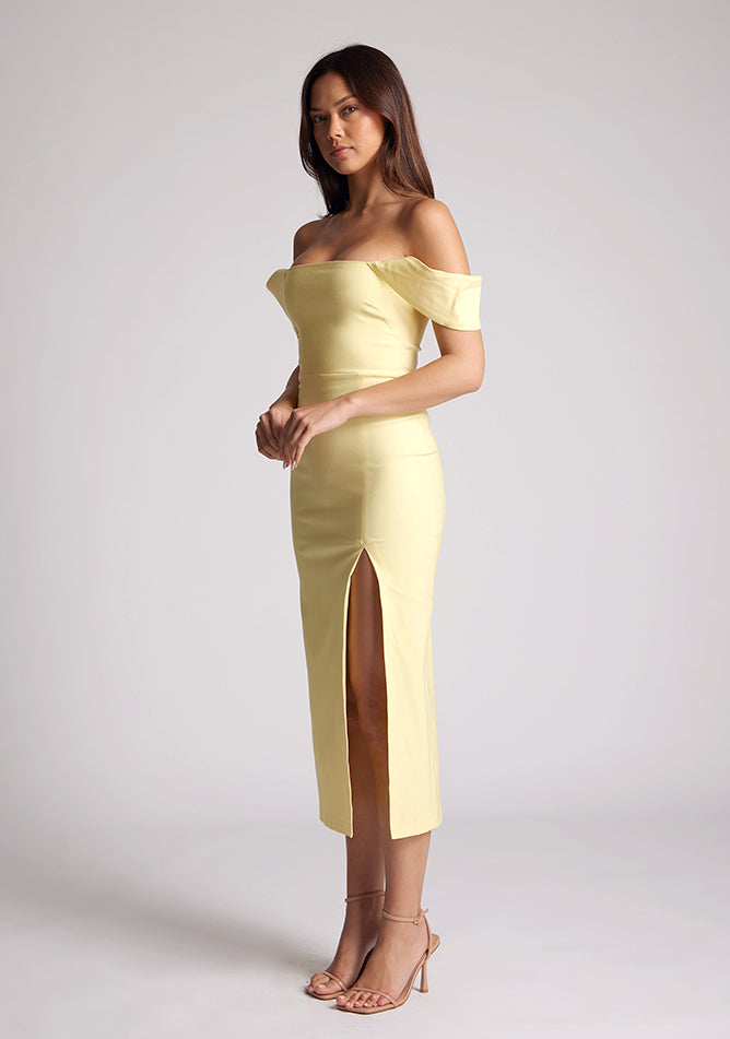 Quarter front image of a model wearing a yellow bardot dress, with a front split. The dress featured is the Astra sherbert bardot midaxi dress