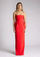 Front image of a model wearing a red square neck maxi dress, featuring delicate straps and waist detailing. The dress featured is the Vesper Bergen maxi dress