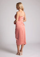 Back quarter image of a model wearing a peach Midaxi Dress with a sweetheart neckline with a spaghetti strap, a wrap-bust style, and a wrap skirt detail, a design features Brooklyn Peach Midaxi Dress