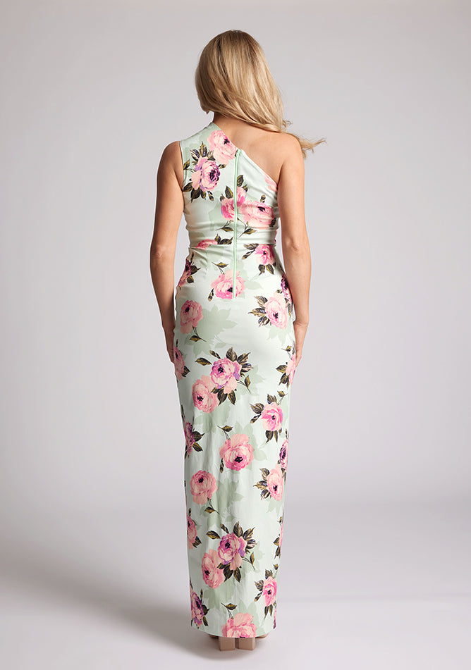 Back image of a model wearing a floral maxi dress with one shoulder. The dress featured is the Charlotte mint floral maxi dress