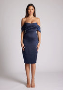 Front image of a model wearing a navy satin midi dress, featuring a pleated panel across the front and two arm bands. The dress featured is the Vesper Fleur navy midi dress
