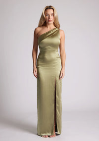 Front image of a model wearing an olive satin dress in a maxi length. This dress features a one shoulder detail and asymmetric neckline with a band across the neckline and front skirt split. The dress featured is Vesper Fliss olive maxi dress