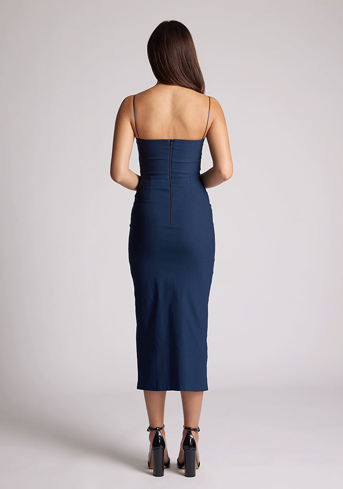 Back image of a model wearing a navy dress with two cut out sections at the bust. The dress featured is the Kendall navy midaxi dress