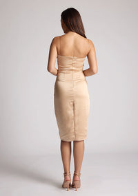 Back image of a model wearing a champagne midi dress, featuring delicate straps and a ruched design at the bust. The dress featured is the Vesper Lisa champagne midi dress