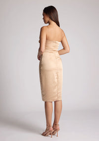 Back quarter image of a model wearing a champagne midi dress, featuring delicate straps and a ruched design at the bust. The dress featured is the Vesper Lisa champagne midi dress