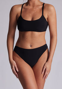 Model wearing the Luxe Element Luna Lace Back Brief showing the sleek Black Fabric, subtle contouring, and comfortable waistband, styled in a neutral studio setting.