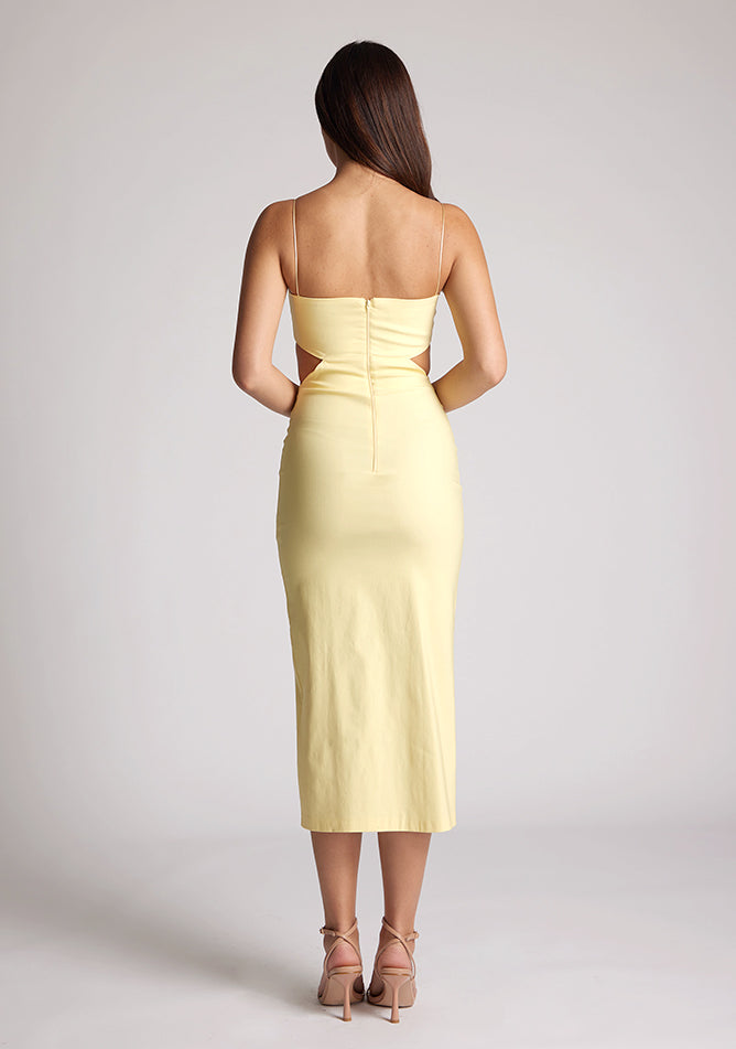Back image of a model wearing a sherbert midi dress, featuring cut outs at the waist and a front split in the skirt. The dress featured is the Vesper Marilynn sherbert midaxi dress