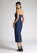 Back quarter image of a model wearing a navy midaxi dress, featuring a sweetheart neckline and a front skirt split. The dress featured is the Vesper Miren navy midaxi dress