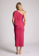 Back image of a model wearing a cerise midaxi dress, featuring a one shoulder design and a front side split. The dress featured is the Vesper Odette cerise midaxi dress