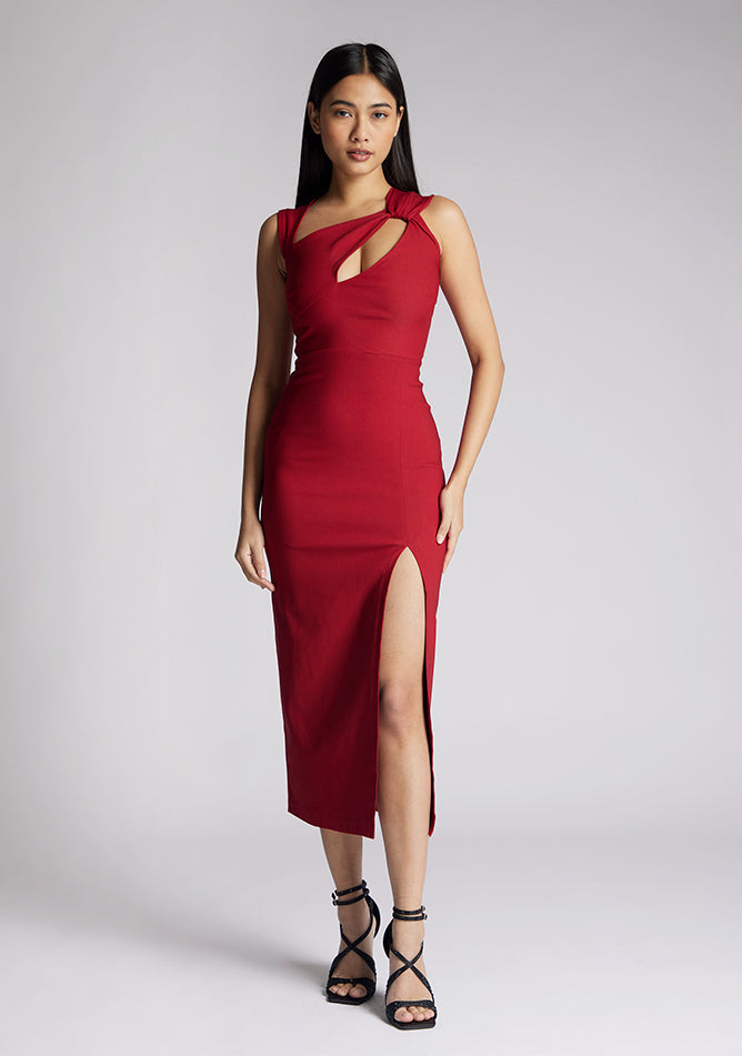 Front image of a model wearing a wine midaxi dress, featuring a cut out at the front and asymmetric straps. The dress featured is the Vesper Queenie wine midaxi dress