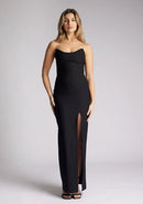 Front image of a model wearing a black maxi dress, with a strapless design and front skirt split. The dress featured is the Vesper Remington black maxi dress