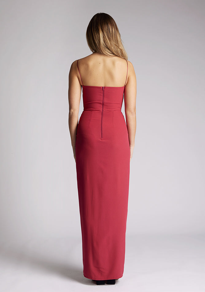 Back image of a model wearing a raspberry maxi dress, featuring delicate straps and a front skirt split. The dress featured is the Vesper Tate raspberry maxi dress