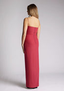 Back quarter image of a model wearing a raspberry maxi dress, featuring delicate straps and a front skirt split. The dress featured is the Vesper Tate raspberry maxi dress