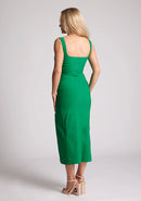 Back quarter image of the model wearing a emerald bodycon midaxi dress with a square neckline and a front split. The design featured is the Vesper Abbie Emerald Midaxi Dress