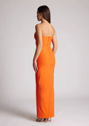 Back quarter image of a model wearing an orange strapless maxi dress with a front split and centre back zip. The design featured is the Vesper Alaya Orange Bodycon Maxi Dress.