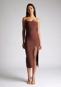 Front image of the model wearing a Chocolate Midaxi Dress with a straight-across neckline and delicate thin straps, and a front skirt split. The design featured is the Vesper Alyssa Chocolate Midaxi Dress