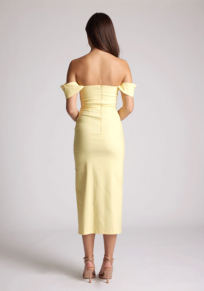 Back image of a model wearing a yellow bardot midaxi dress with a stunning bardot neckline with armbands and a front skirt split. The design featured is the Vesper Astra Yellow Bardot Midaxi Dress