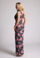Back quarter image of a model wearing a green floral maxi dress with a  asymmetric one-shoulder design, delicate pleats and front skirt split. The design featured is the Vesper Charlotte Green Floral Maxi Dress