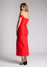 Quarter back  image of a model wearing a red midaxi dress, featuring a bardot neckline with subtle sweetheart detail, off shoulder style bands and a front skirt split. The style featured is Vesper Clara Red Midaxi Dress.