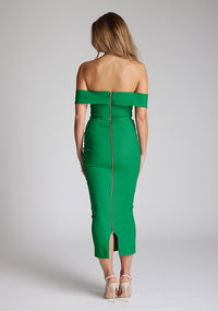 Back image of a model wearing a emerald green midaxi dress with a off-shoulder bardot neckline, with arm bands v-shaped cut-out at neckline and keyhole cut-out under bust and bodycon style dress with a statement gold zip at centre back. The design featured is the Vesper Daphne Emerald Green Midaxi Dress