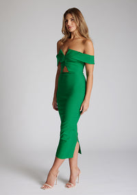 Front quarter image of a model wearing a emerald green midaxi dress with a off-shoulder bardot neckline, with arm bands v-shaped cut-out at neckline and keyhole cut-out under bust and bodycon style dress with a statement gold zip at centre back. The design featured is the Vesper Daphne Emerald Green Midaxi Dress
