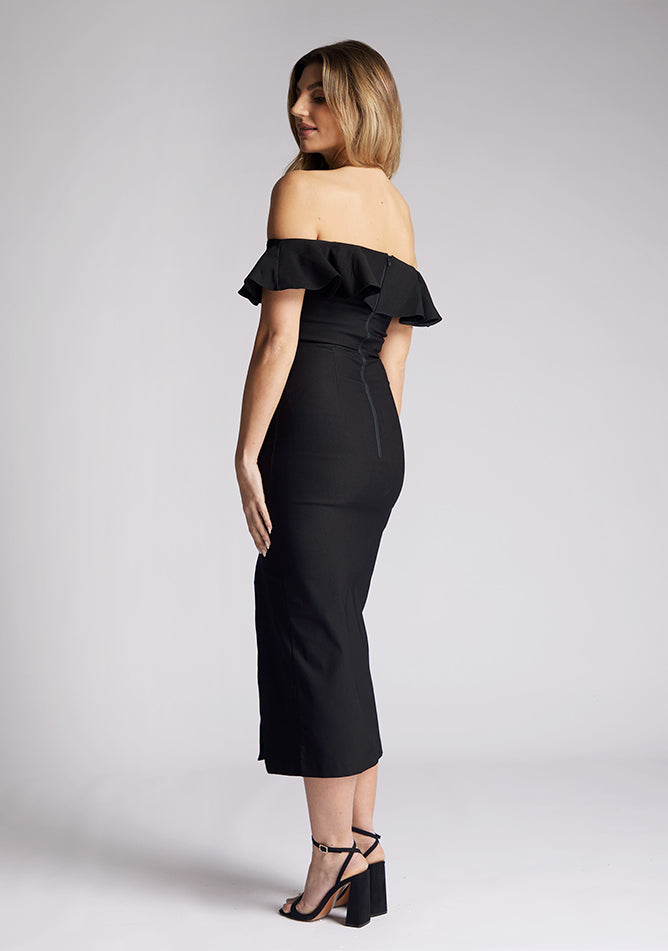Quarter back image of a model wearing a black midaxi dress, featuring a bardot neckline with a ruffle design, front skirt split and invisible centre back zip. The style featured is Vesper Deirdre Black Midaxi Dress.