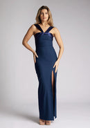 Front image of a model wearing navy maxi dress with a chic neckline, sleeveless silhouette, figure-hugging body con design and satin panel at the top which twists up into straps. The design featured is the Vesper Fame Navy Maxi Dress