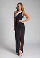 Front quarter image of a brunette model wearing a monochrome dress in a maxi length with a asymmetric neckline, an ivory satin band across the neckline, thigh-high leg split and figure-hugging stretch crepe fabric with a white band across neckline. The design featured is the Vesper Fliss Monochrome Maxi Dress
