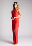 Quarter front image of a model wearing a red halter neck maxi dress, featuring a keyhole cut out and a front skirt split. The dress featured is the Vesper Ivie red maxi dress