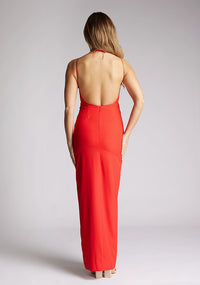 Back image of a model wearing a red strappy maxi dress with a halter neckline with a chic back fastening and subtle keyhole detail, its backless design exudes refinement and front skirt split. The design featured is the Vesper Ivie Red Strappy Maxi Dress