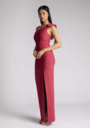 Front quarter image of a model wearing a raspberry maxi dress, featuring an asymmetric neckline, one shoulder with statement bow detail and a front skirt split. The dress featured is Vesper Keegan Raspberry One Shoulder Maxi Dress