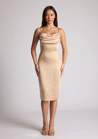 Front image of the model wearing a champagne satin midi dress with a mesmerising cowl neckline with delicate thin straps made from high-shine allure satin. The design featured is the Vesper Lisa Champagne Satin Midi Dress