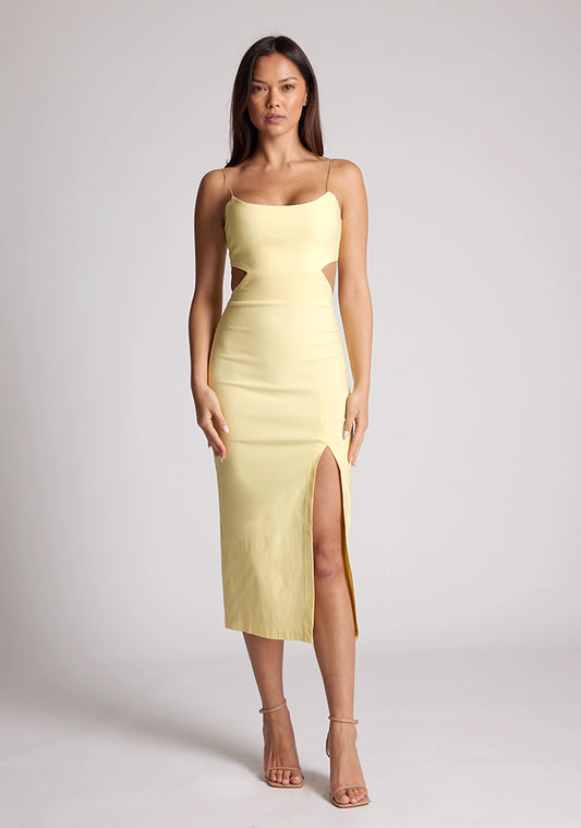 Front image of a model wearing a yellow midaxi dress with a graceful scoop neckline, slender straps, subtle side cut-out and it offers both mobility and modern flair with a front skirt split. The design featured is the Vesper Marilynn Yellow Midaxi Dress