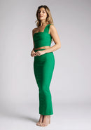 Front  quarter image of a blonde model wearing a emerald one shoulder top with a one-shoulder cut and straight neckline, side pleating and a size zip. The design featured is the Vesper Matilda Emerald One Shoulder Top pair with Vesper Hana Emerald Skirt