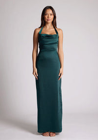 Front image of a model wearing a pine maxi dress with a halter cowl neck exudes sophistication, while the lustrous satin fabric offers a luxurious touch. The design featured is the Vesper Saige Pine Satin Green Maxi Dress