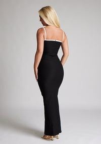 Back quarter image of a  model wearing a monochrome maxi dress with a square neckline with thin straps and a bodycon fit. The design featured is the Vesper Sienna Monochrome Bodycon Maxi Dress