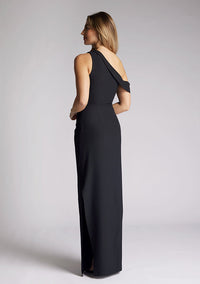 Back quarter  image of a model wearing a black maxi dress, featuring a one shoulder design with a band that encompasses the opposite arm. The dress featured is the Vesper Yvette black maxi dress