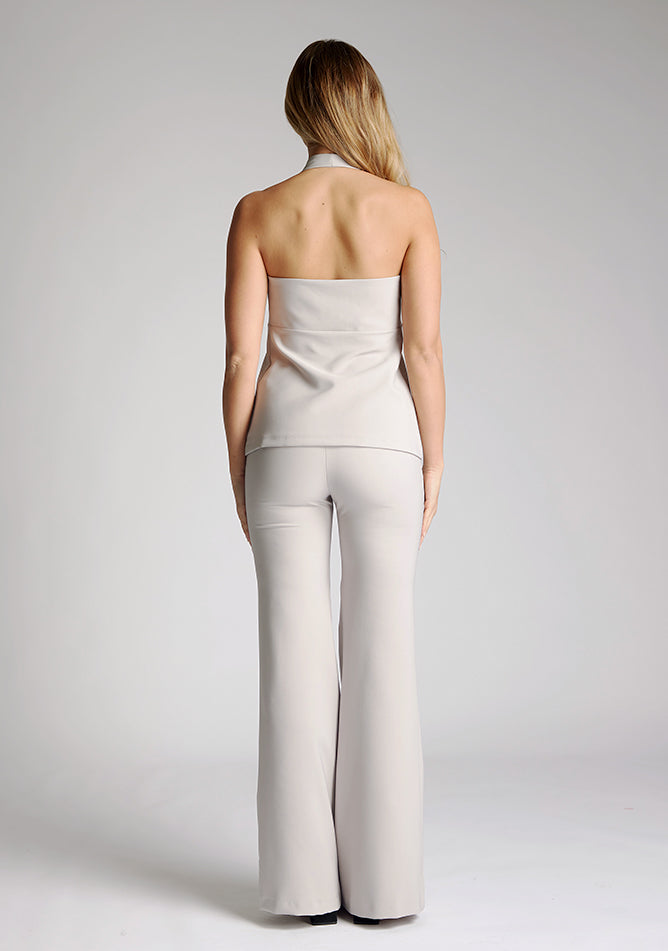 Back image of blonde model wearing a grey Waistcoat with a v-neckline with the gold button detail with chich high waisted wide leg trousers a items featured are Vesper grey Black Waistcoat and Vesper Elton Grey Trousers 